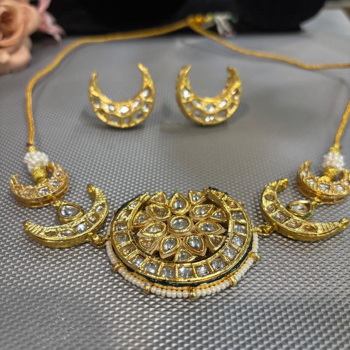 Crescent moon choker necklace set with white Kundan stones and pearl border in gold plating made in brass