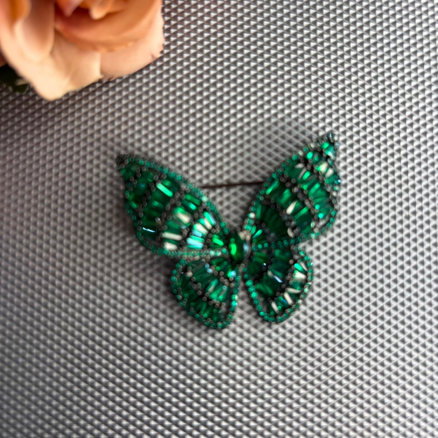 Emerald green crystal butterfly brooch with black rhodium finish and premium baguette stones.