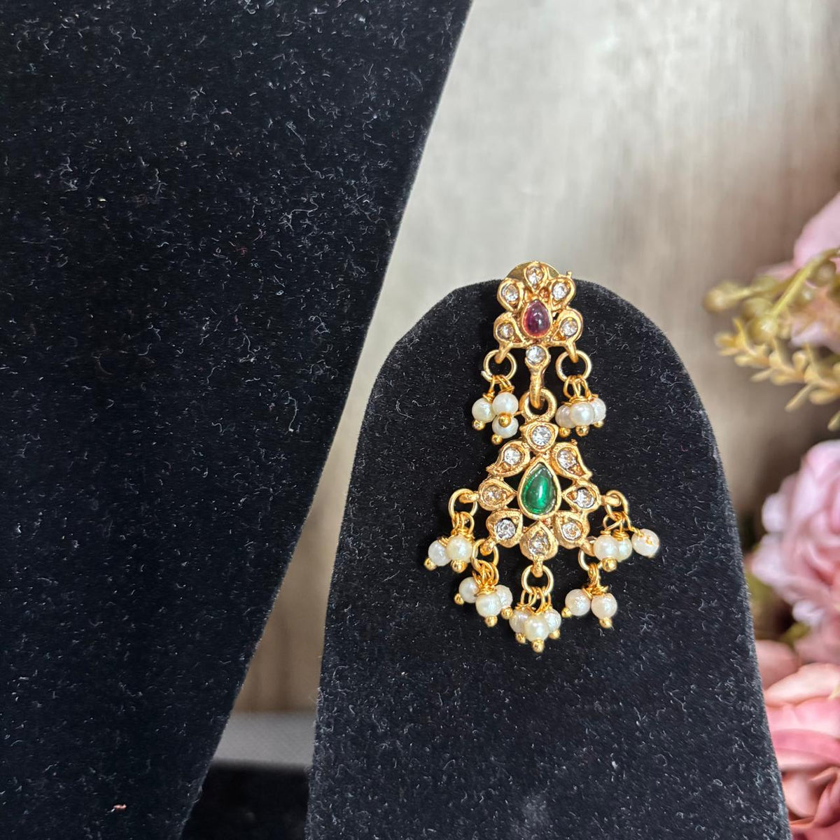 Women wearing traditional Gold-tone diamond style earrings with green centre stone, ruby accents and pearls cluster