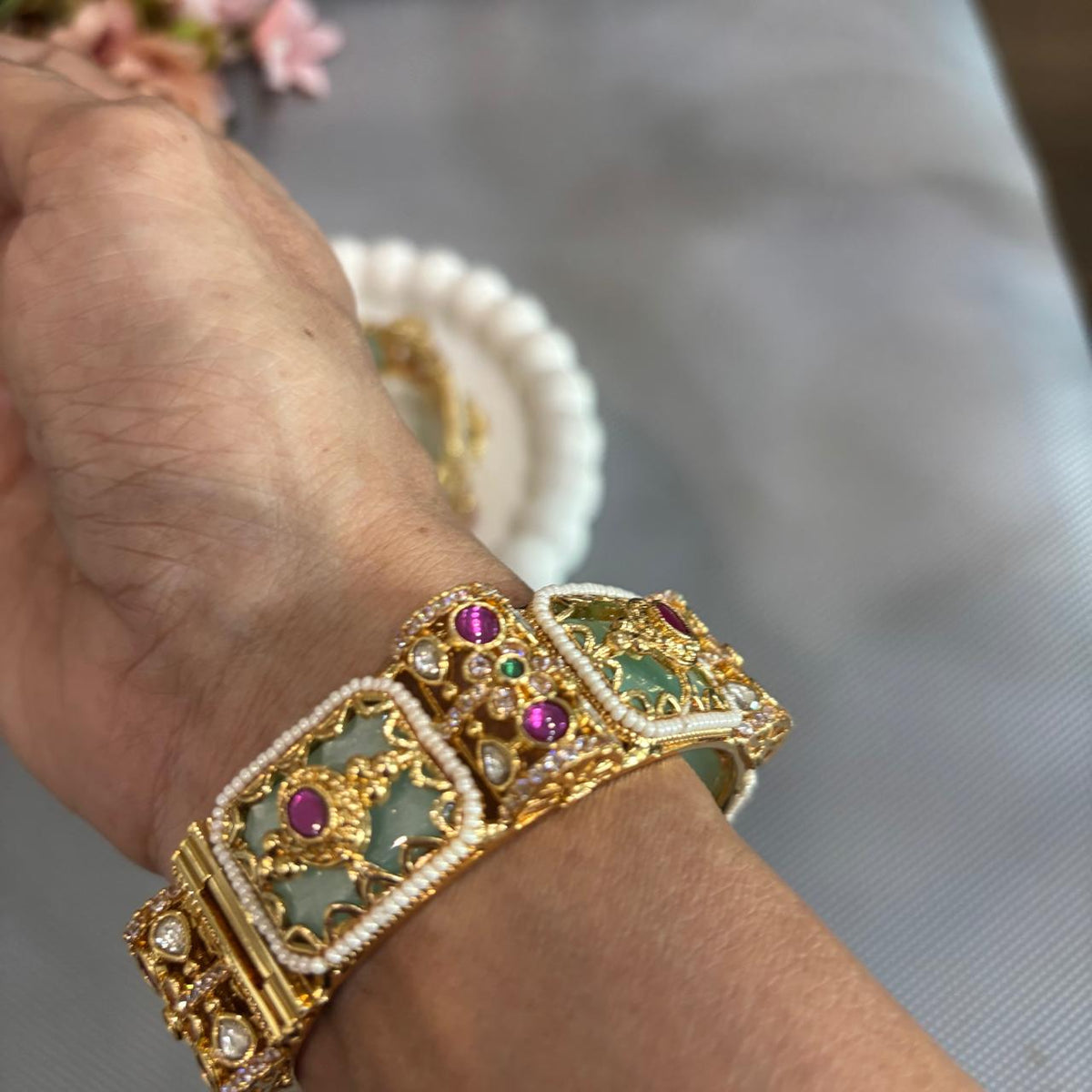 Close up of women wearing mint green rajwada kada with ruby and kundan in gold plating