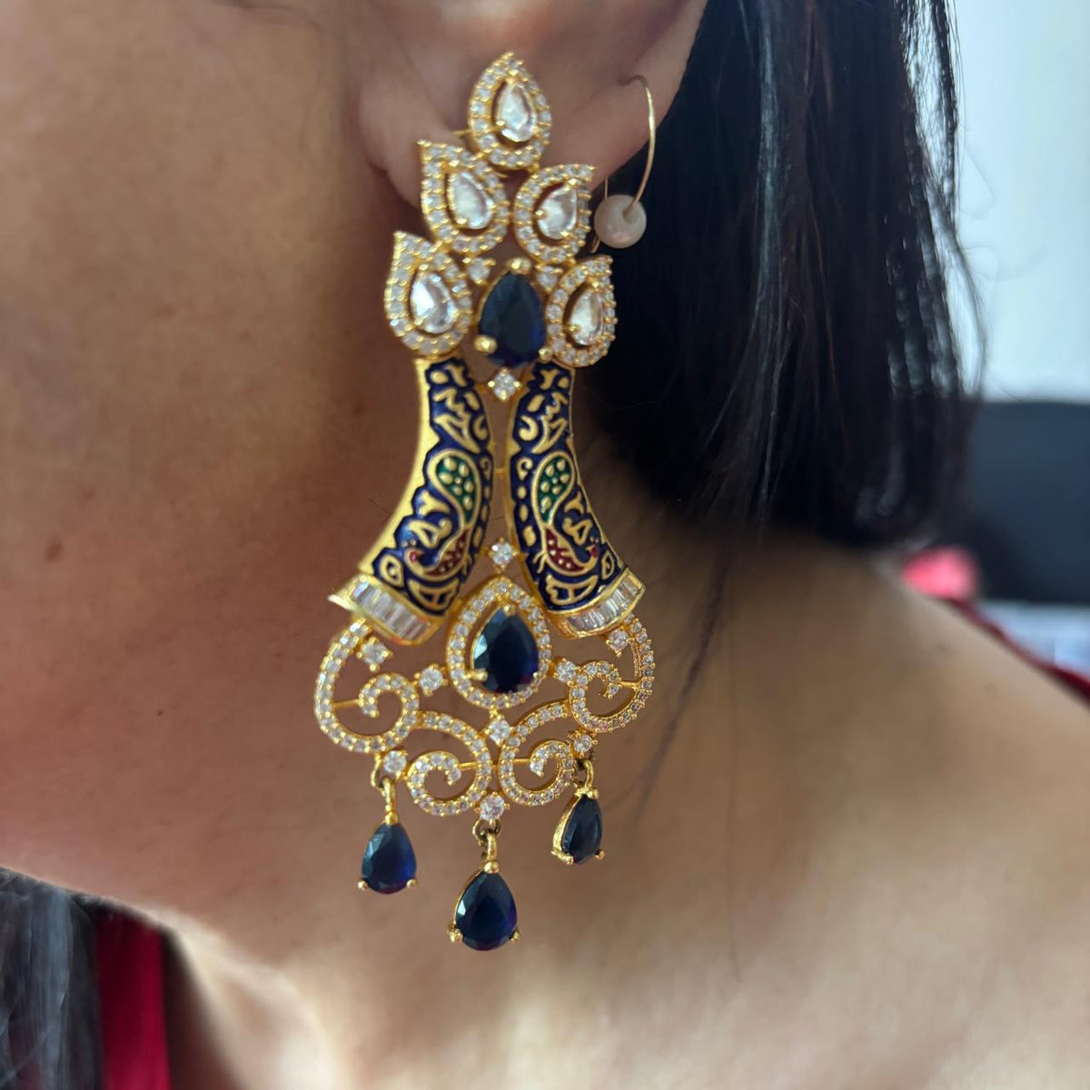 Women wearing Pair of AD chandelier cocktail earrings with blue stones