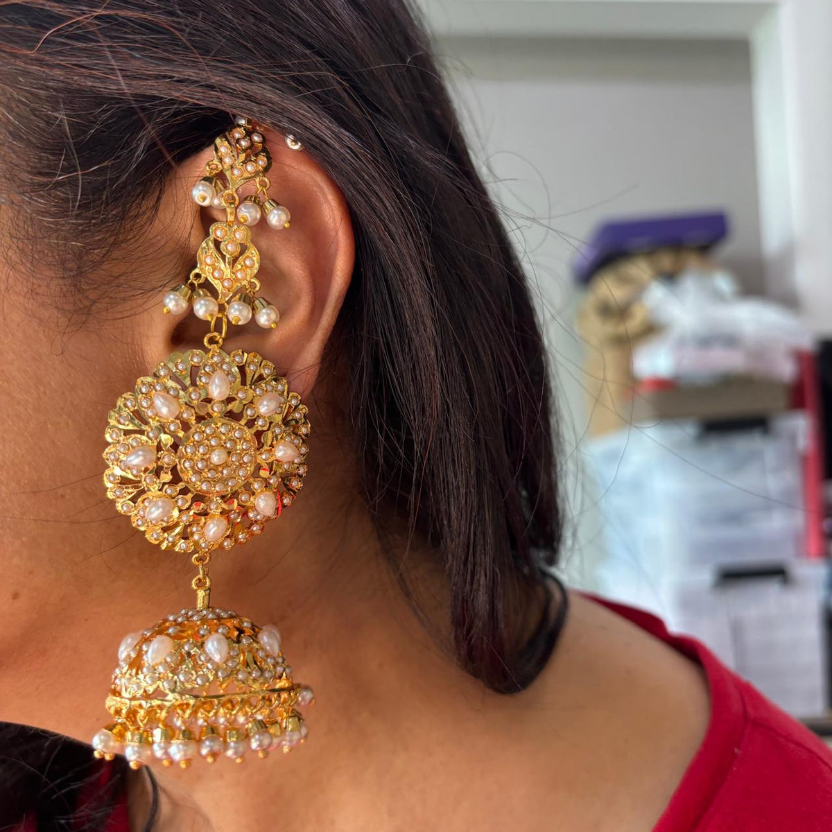 Gold-tone Jadau-style statement jhumka earrings with pearl accents and floral medallion design