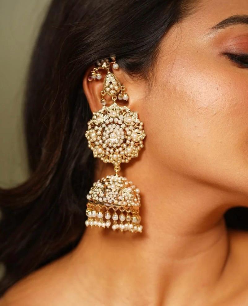 Gold-tone Jadau-style statement jhumka earrings with pearl accents and floral medallion design