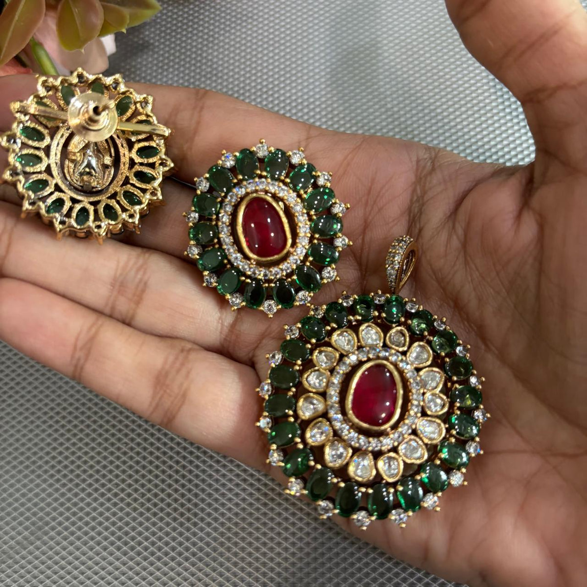 Showing backside of Gold tone pendant set with polki kundan , ruby red and emerald green stones
