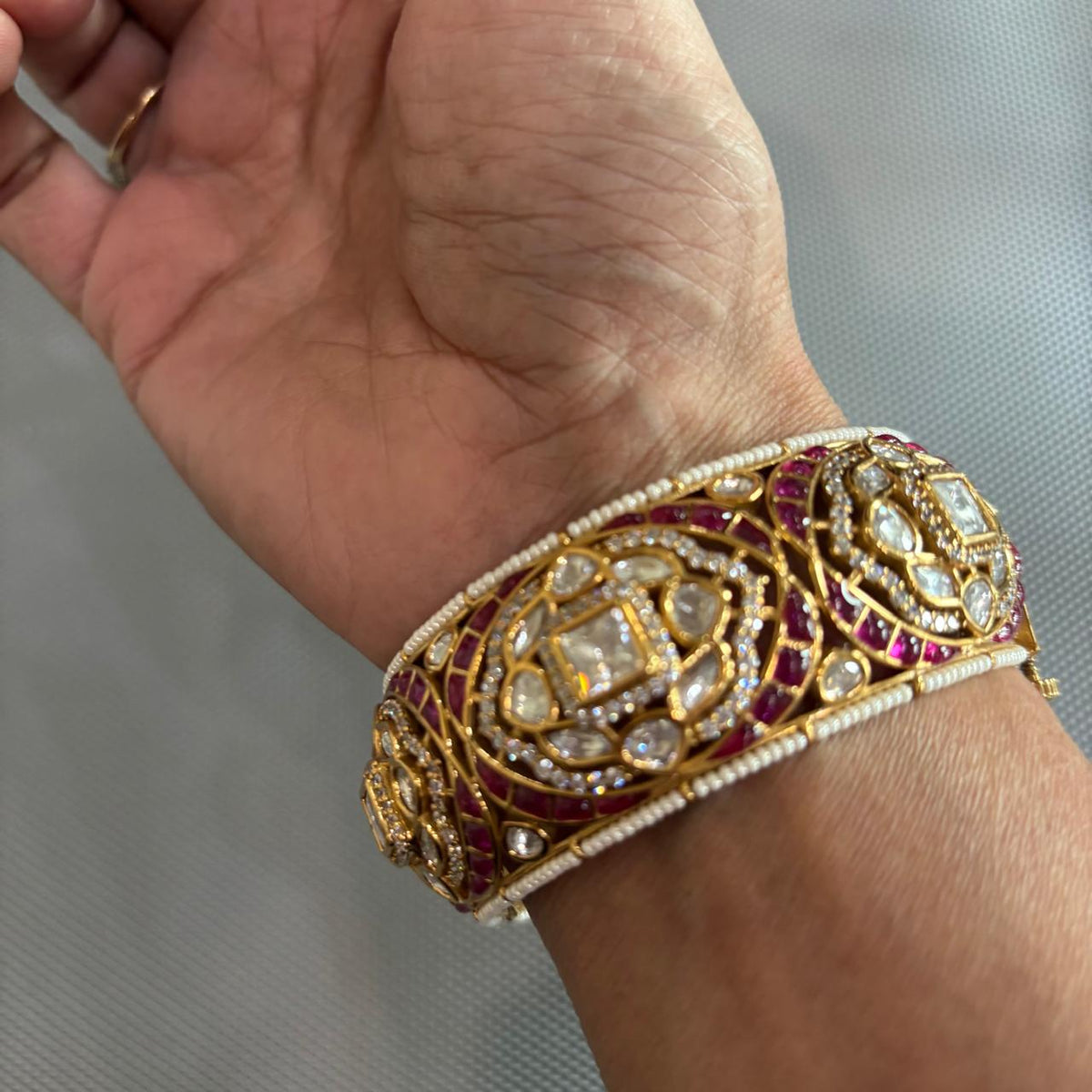 Openable Gold tone moissanite Polki kada with ruby detailing , pearls and uncut diamonds on hand at bebaak jewels