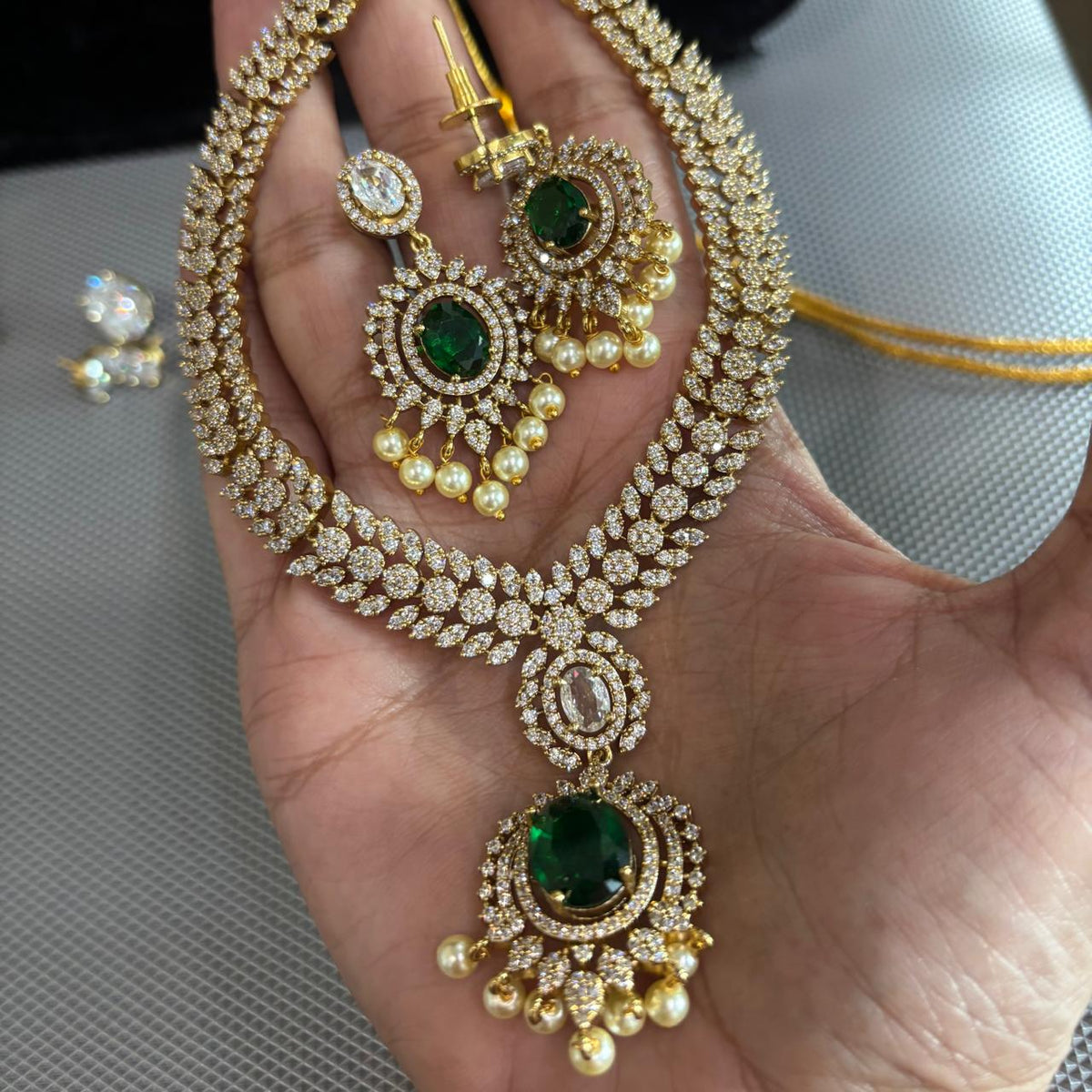 American diamond necklace set in mint green , light pink , clear crystal , emerald green and ruby coloured jewellery stones in gold tone settings