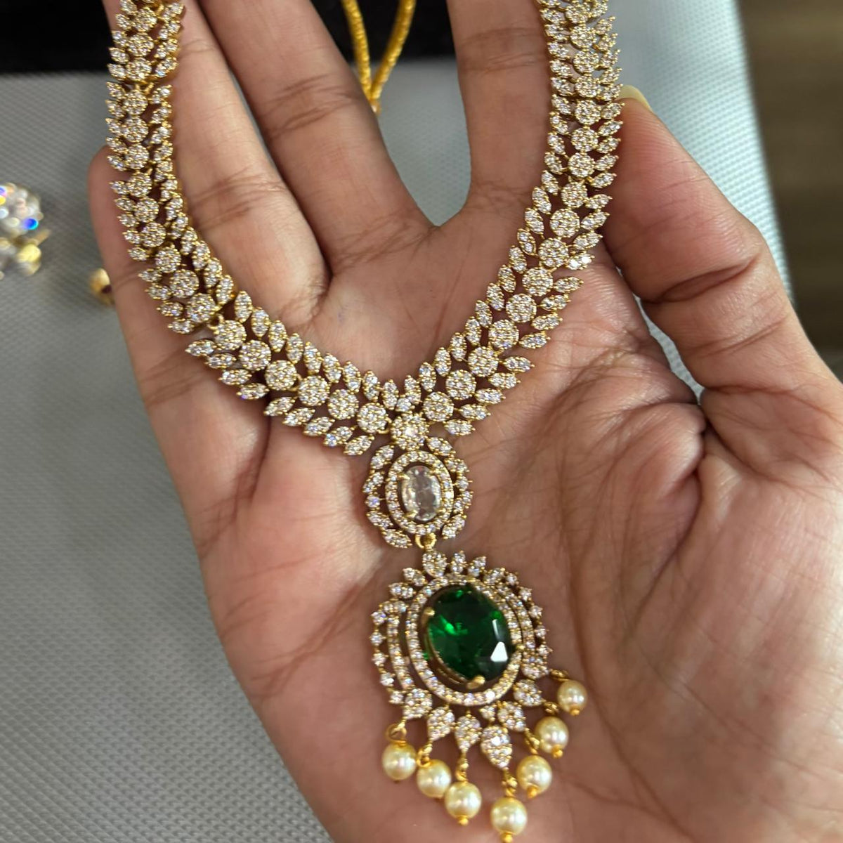 American diamond necklace set in mint green , light pink , clear crystal , emerald green and ruby coloured jewellery stones in gold tone settings
