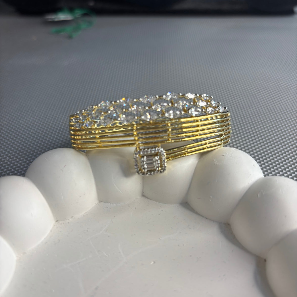 Anshi gold-plated American diamond bracelet displayed on a white stand