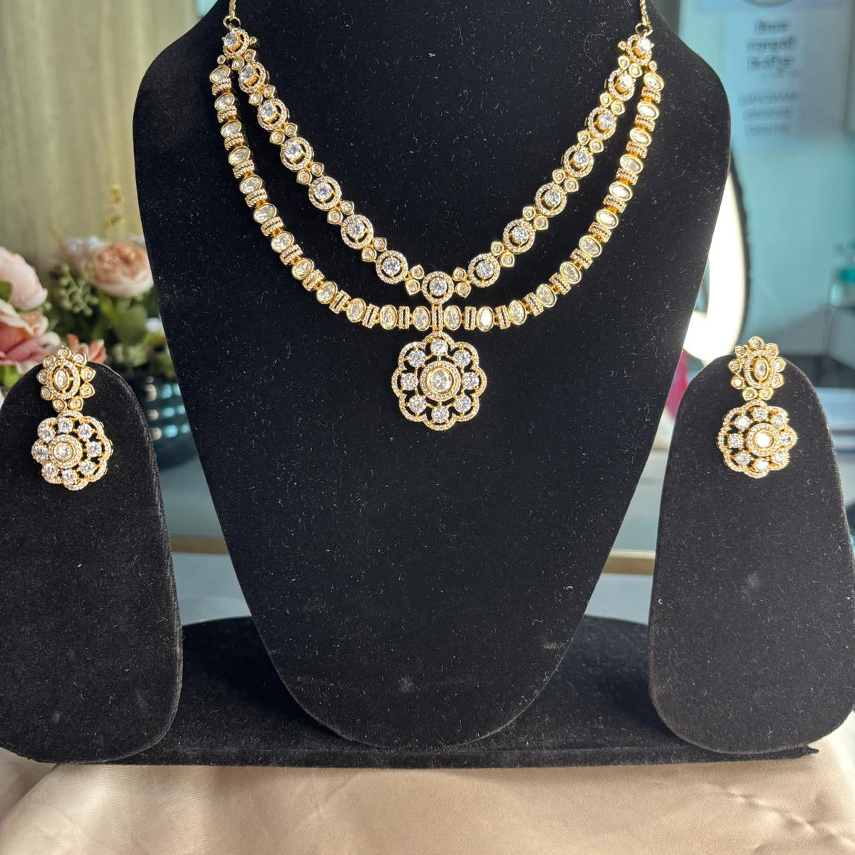 Ahana double layer solitaire American Diamond necklace set with floral pendant and matching earrings in gold finish for bridal and party wear.