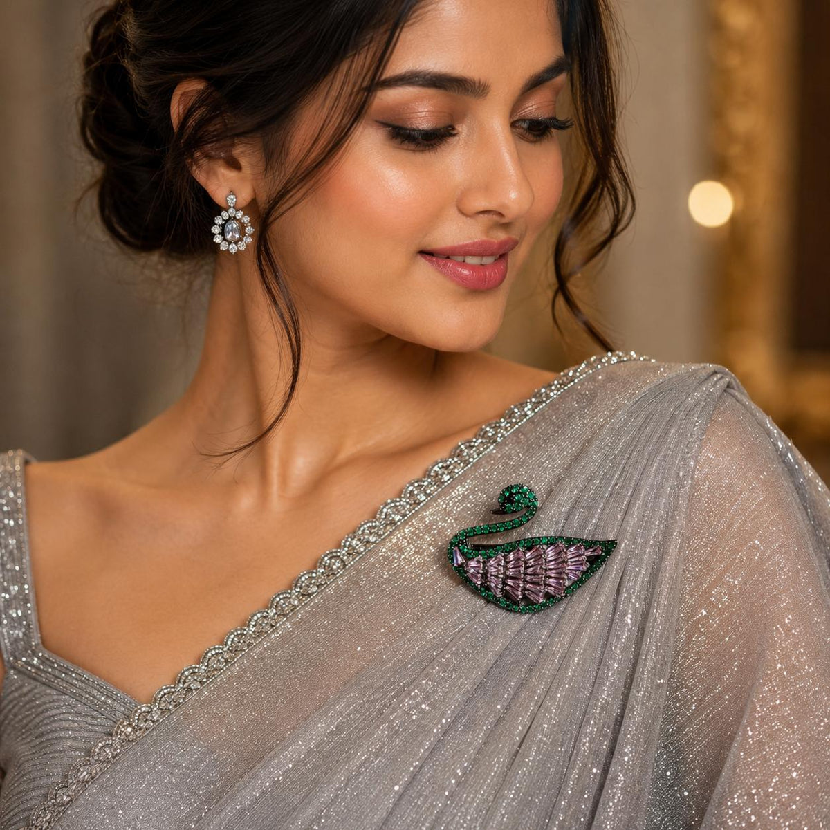 Elegant lavender and emerald crystals swan brooch on a women with grey shimmer saree