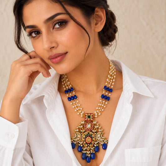 Woman wearing Lapis blue stone drops Kundan necklace with red enamel and pearls