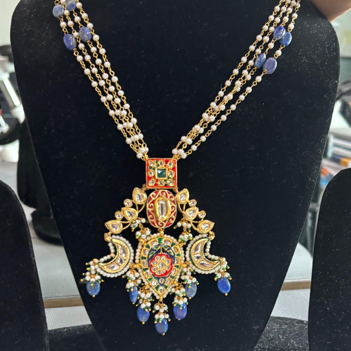 Lapis Lazuli drops Kundan necklace with red enamel and pearls on display