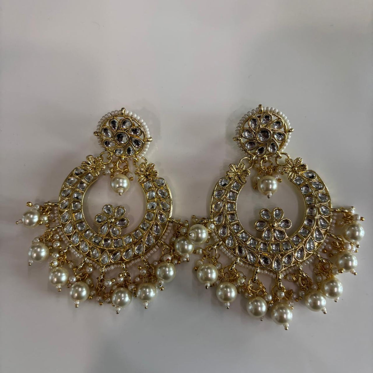 Oversized Kundan chandbali earrings with pearl drops and floral detailing