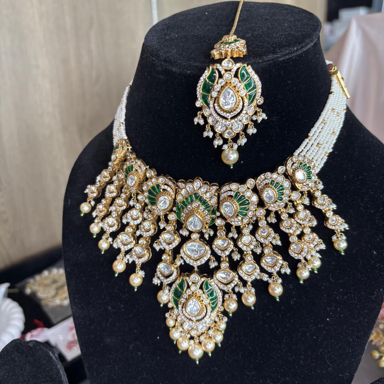 Luxury Emerald Green Kundan Bridal Necklace Set with Matching Earrings and Maang Tikka by Bebaak Jewels.