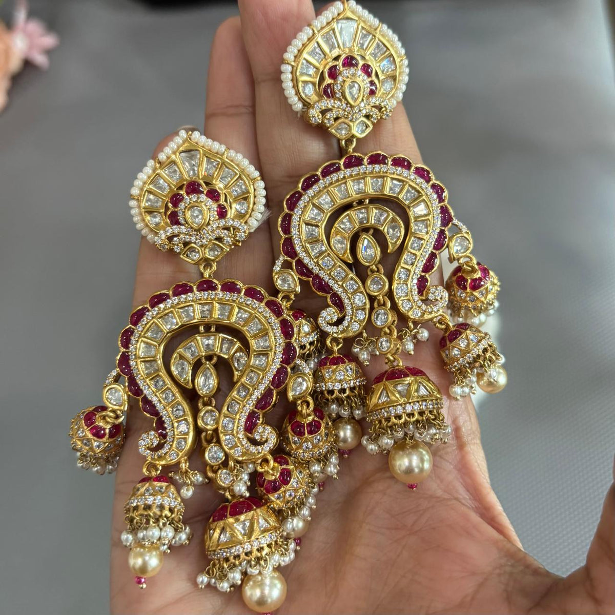 Handheld Maharani Kundan jhumka earrings worn on ear showing long statement size
