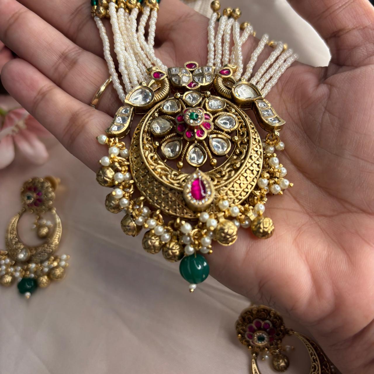 Rajwadi Kundan pearl  long necklace set with antique gold finish, multi-layer pearl strands, ruby accents, emerald green bead drops and matching chandbali earrings.