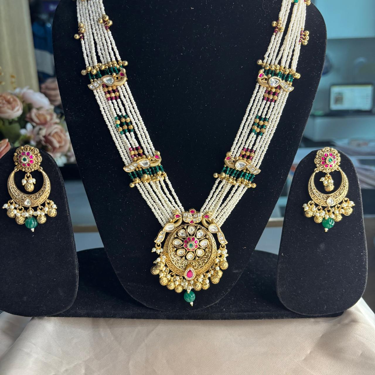 Rajwadi Kundan pearl  long necklace set with antique gold finish, multi-layer pearl strands, ruby accents, emerald green bead drops and matching chandbali earrings.
