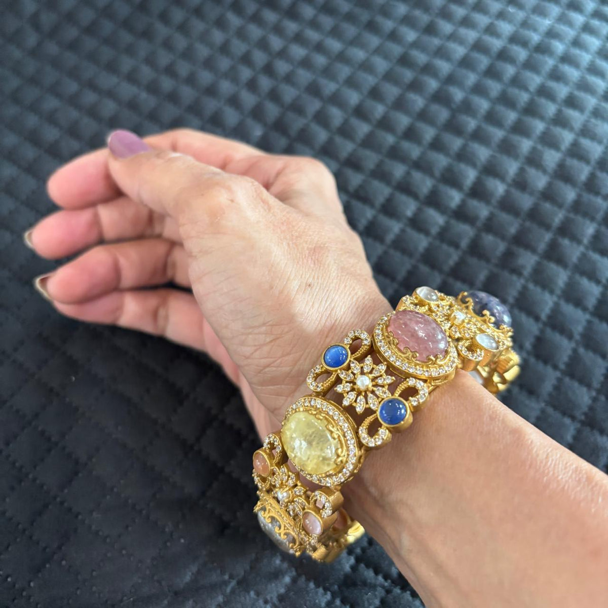 Sabya multistone openable kada bracelet with colourful stones and crystal detailing on a hand 
