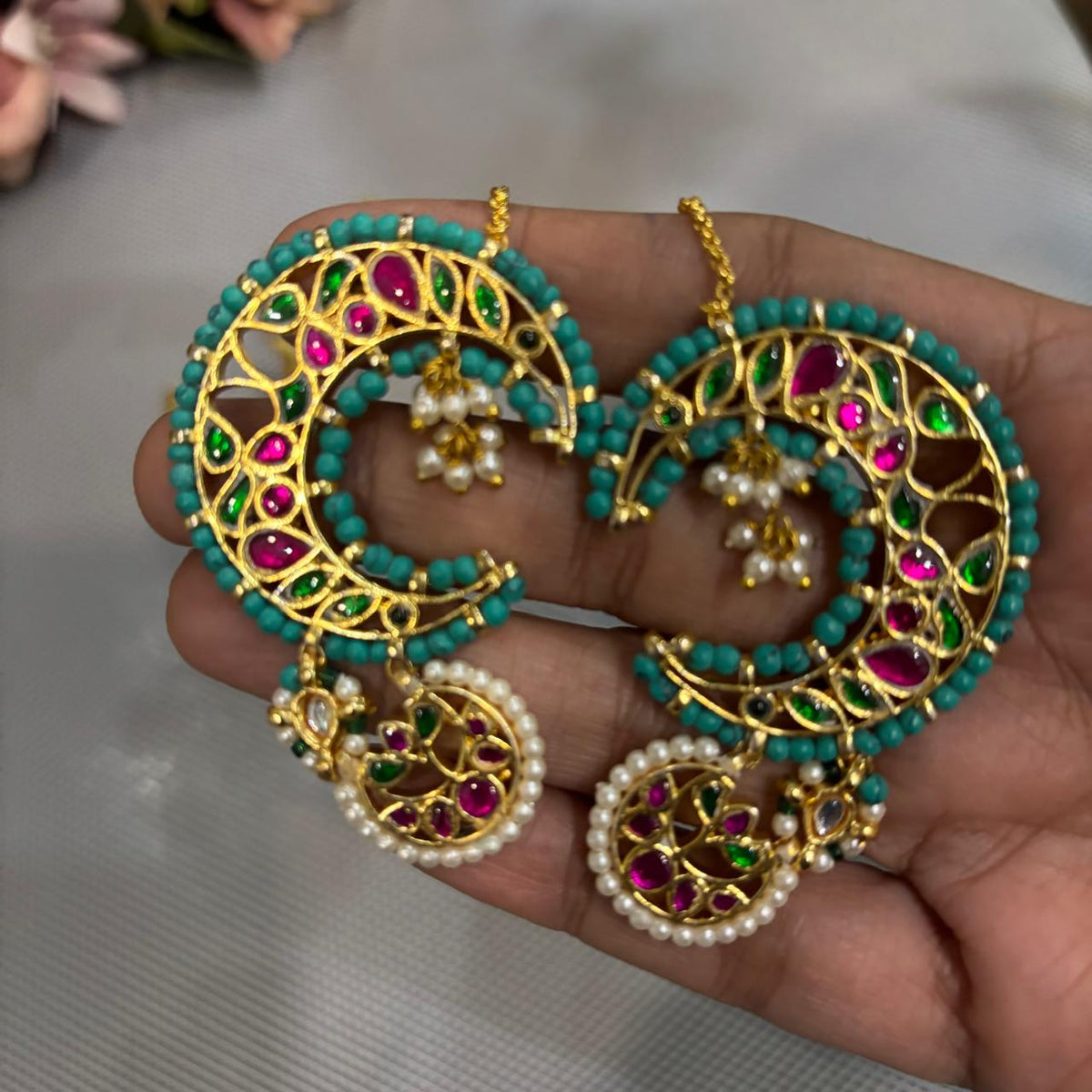 Close up of Traditional turquoise Kundan kaanphool statement earring with pearls styled for wedding wear