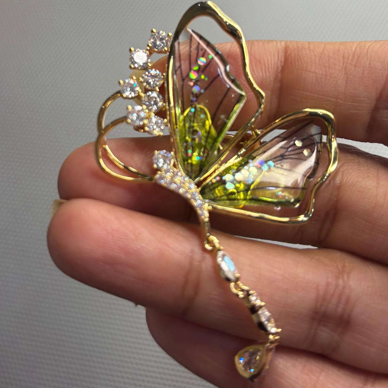 Soft green butterfly brooch with sparkling diamond-look cubic zirconia stones and elegant crystal drop.
