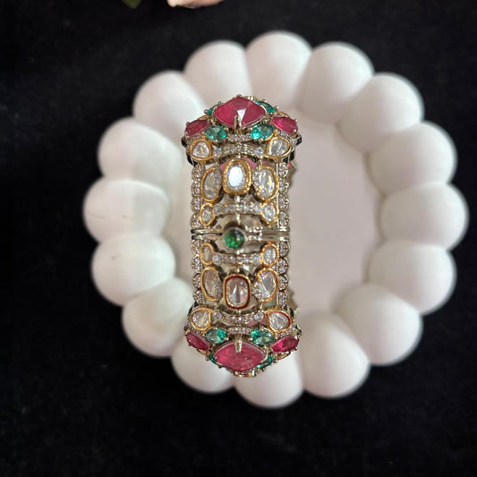Polki moissanite style openable kada on a white tray with pink and green stones