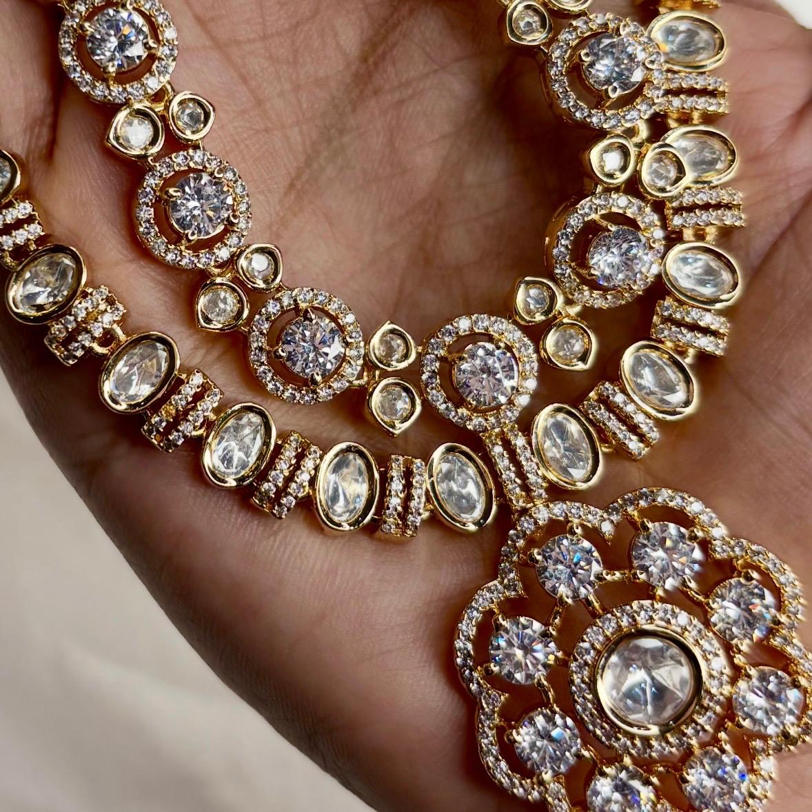 Ahana double layer solitaire American Diamond necklace set with floral pendant and matching earrings in gold finish for bridal and party wear.