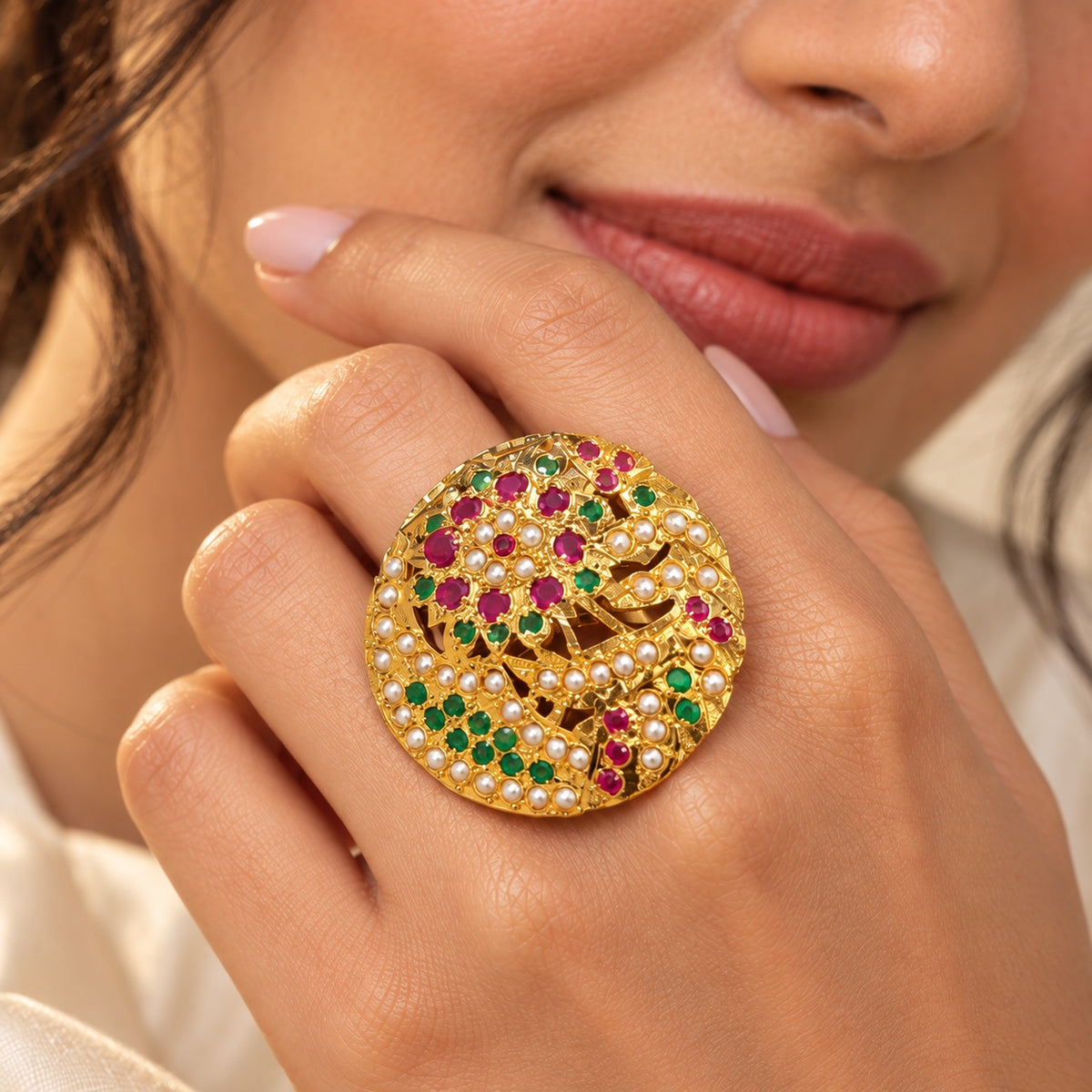 Close-up of the Maahi multicolour Jadau floral statement ring worn on a hand, showing pink and green stones and pearl detailing