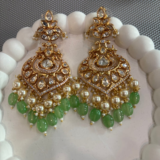Front view of mint-green chandbali earrings with clear teardrop stones and cream pearl-like beads