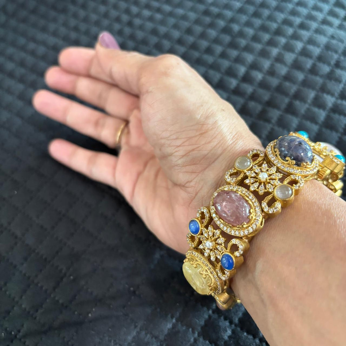 Single multistone kada bracelet with clear crystal and floral embellishments on hand 