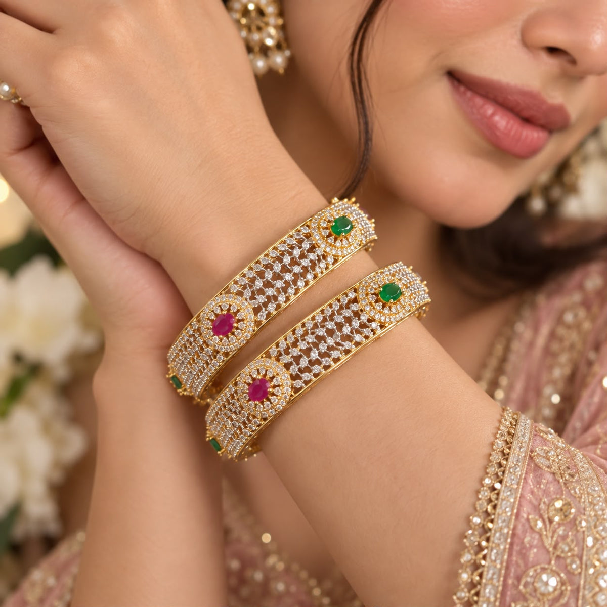 Woman wearing pair of  ruby emerald american diamonds gold tone Bangles 
